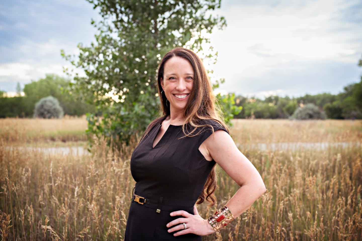 Stephanie Drobny standing in golden prairie grass in the late afternoon light